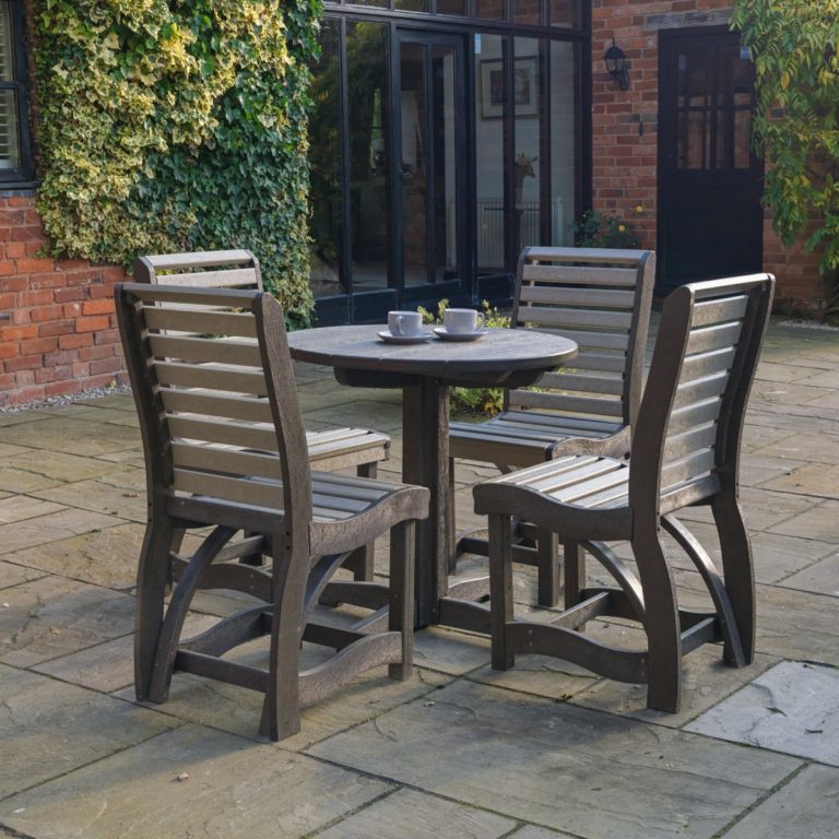 An outdoor round dining table and four chairs made from 100% recycled plastic located on a patio