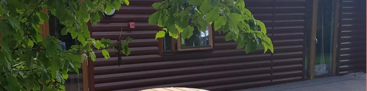 A circular wooden picnic table to seat 6 people on a patio at a holiday park