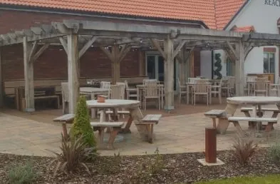 The Kings Reach pub garden with circular 8 seater wooden picnic tables and 8 square teak table and dining chair sets