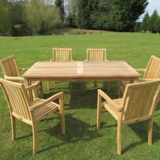 A 1.8m long teak outdoor dining table with 6 chairs around it on a lawn