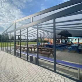 Large aluminium shelter with polycarbonate roof, and glass sides