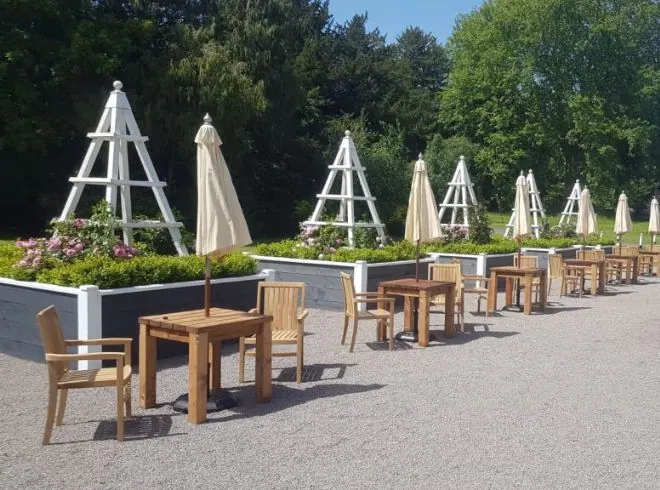 teak chairs and wooden tables, alongside bespoke grey planters